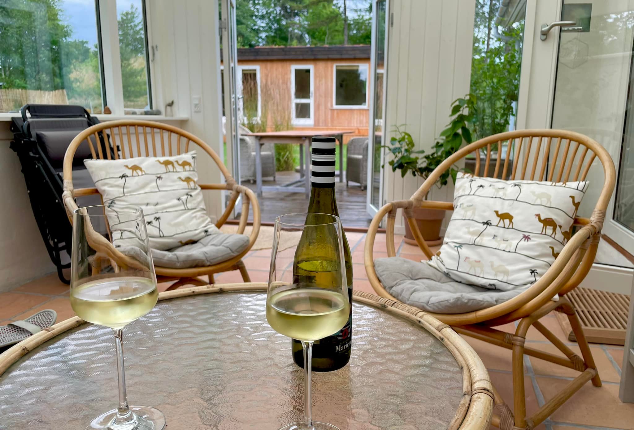 Udestue i sommerhuset i Overby Lyng med to glas vin på bordet